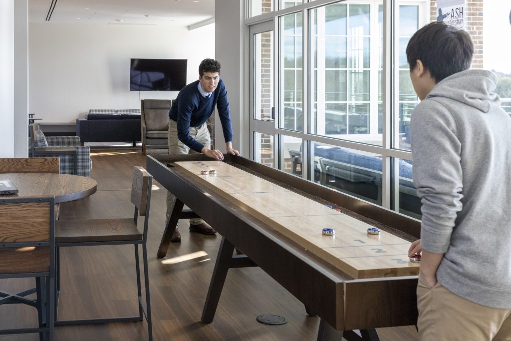 Senior resident students play shuffleboard in the 5th floor senior lounge